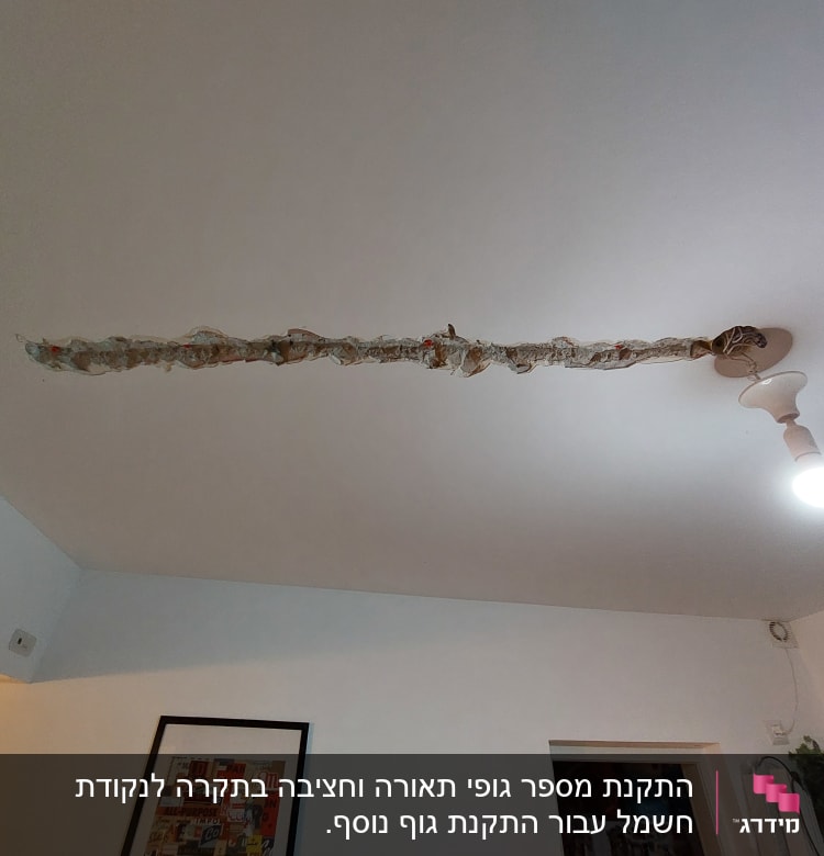 תקרה עם חוטי חשמל חשופים ונורה דולקת